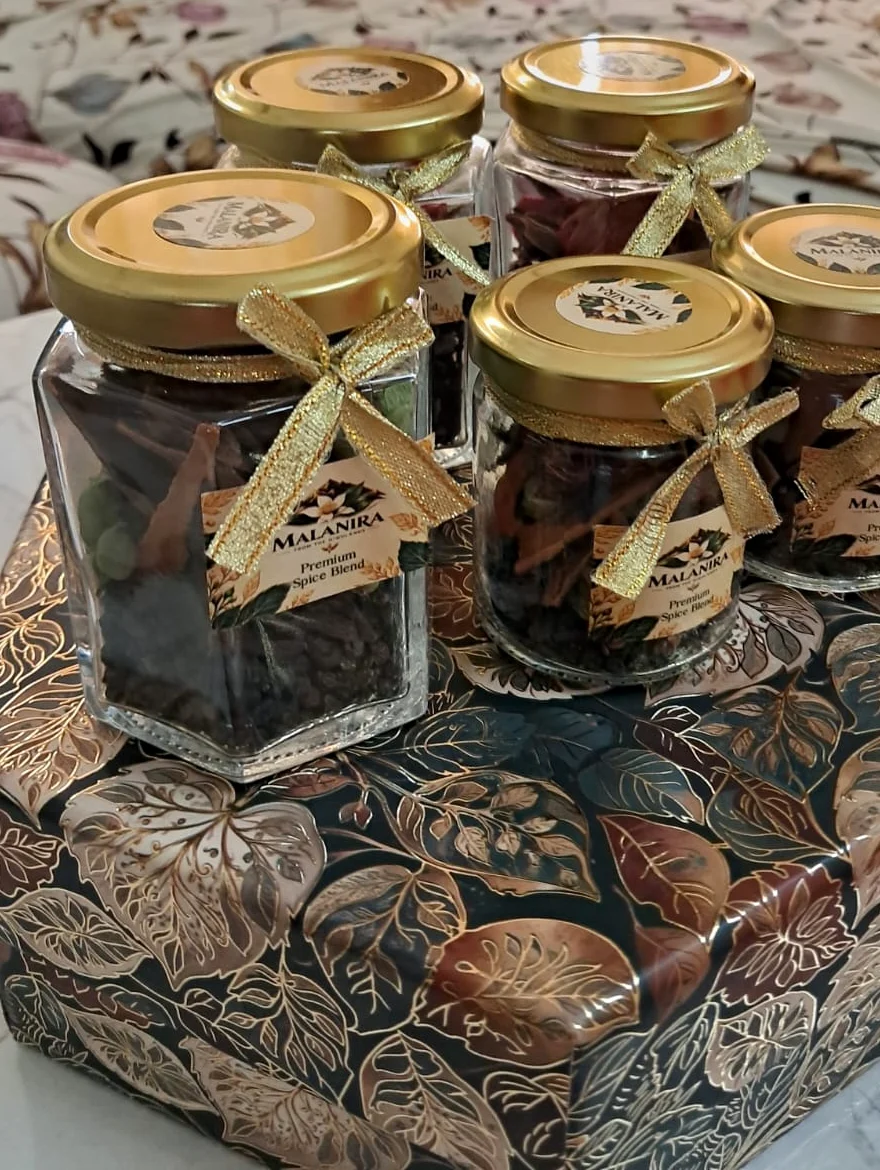Malanira spice jars with gold ribbons on a gift box