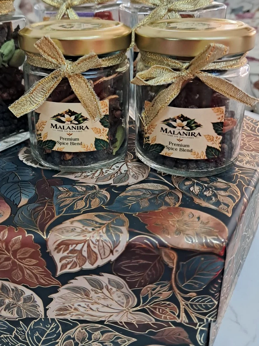 Malanira Premium Spice Blend jars with gold lids and ribbon